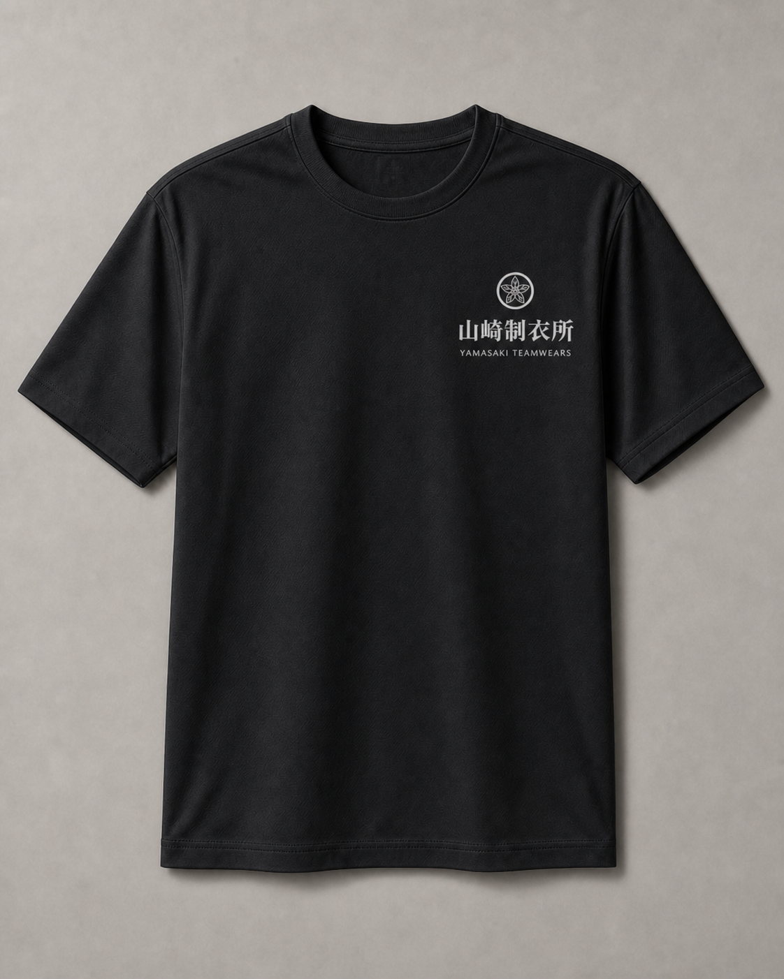 暖灰背景上的黑色 190g 彈性棉 T 恤與山崎制衣所左胸識別示意
